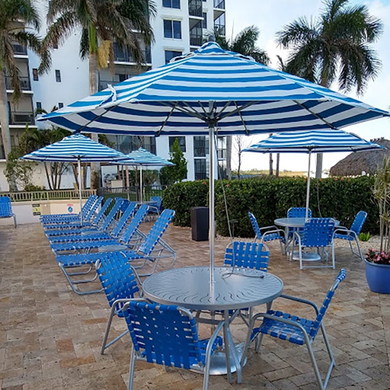 Commercial pool deck featuring royal blue crossweave vinyl strap dining chair and matching chaise lounges designed for resort and condominium pools.